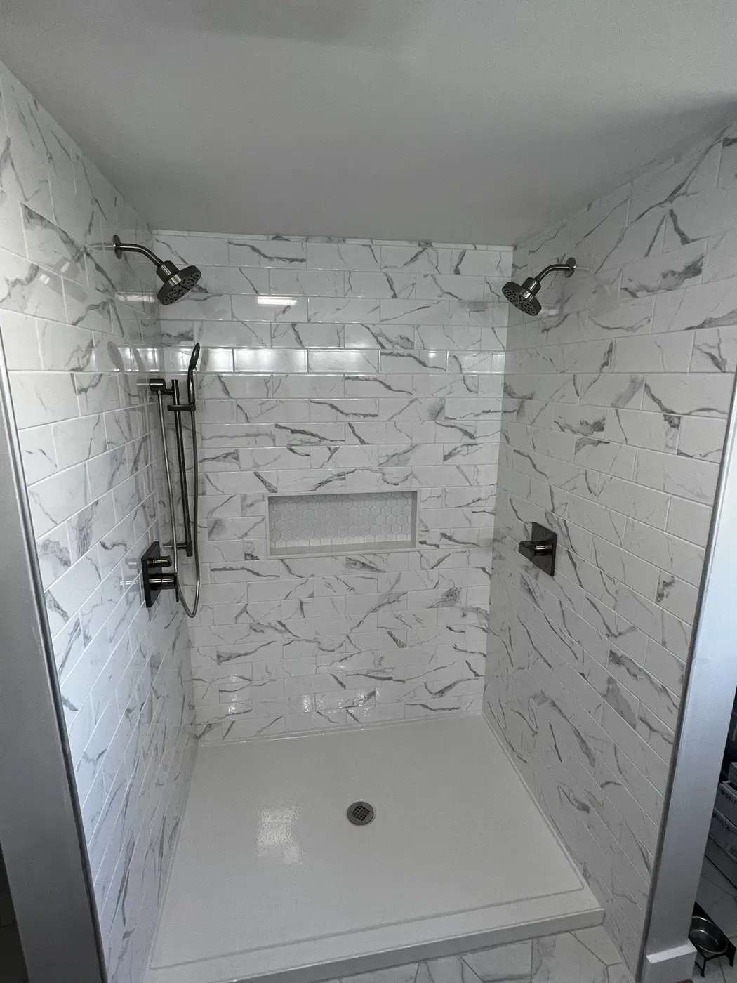 Finished tiled shower with dual shower heads and handheld sprayer, plumbed by MPS207